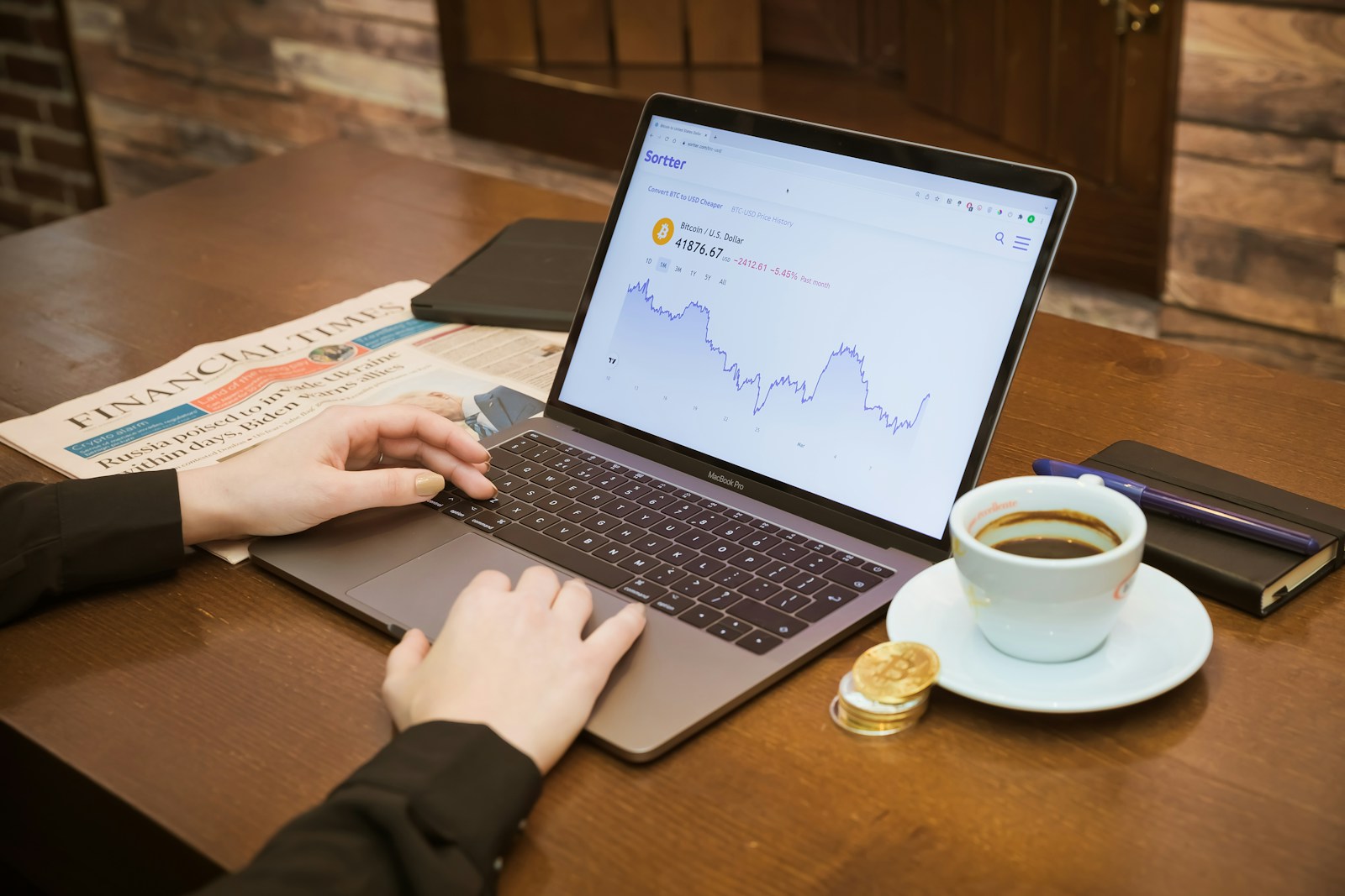 a person using a laptop on a table with a cup of coffee
